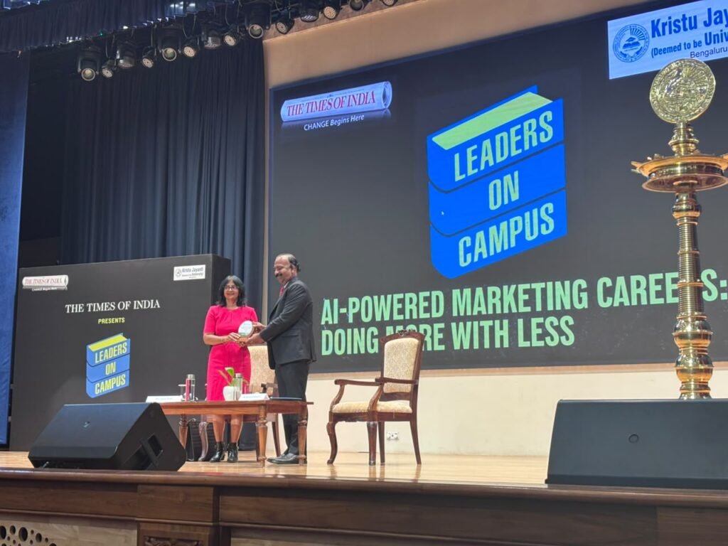 Jessie on stage with Dr J Aloysius Edward, Registrar, Kristu